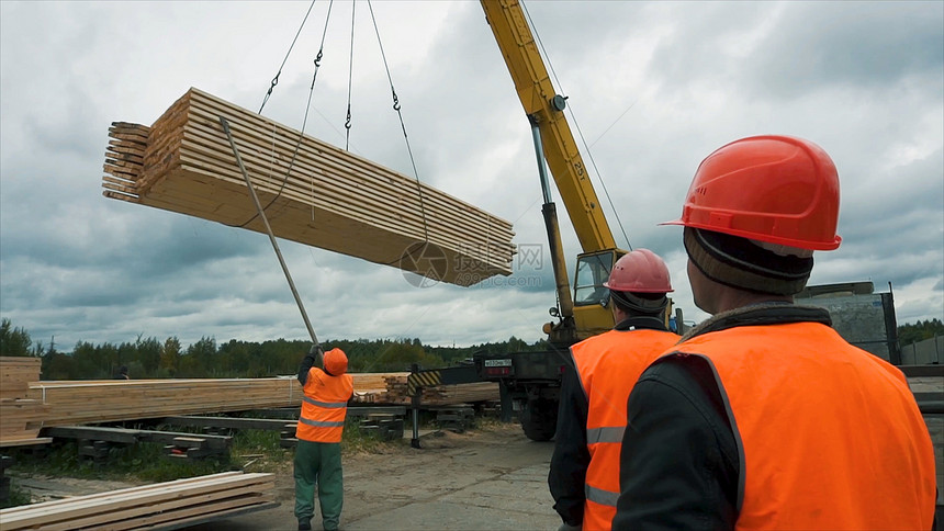 建筑工地的工人使用起重机运送木条工人在建筑工地使用木梯钢筋从混凝土柱中伸图片