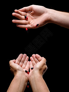 从医生手中接受健康药物的美丽病人手掌的组成黑色和红色的抗生素或药物胶囊在黑色背景的手掌中专图片