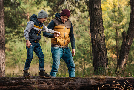 父亲和儿子手牵而男孩在森林图片