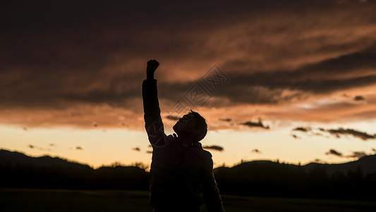 一位男子用乌云举起拳头对抗日背景图片