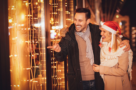 快乐的有吸引力的情侣在度假之夜享受圣诞购物图片