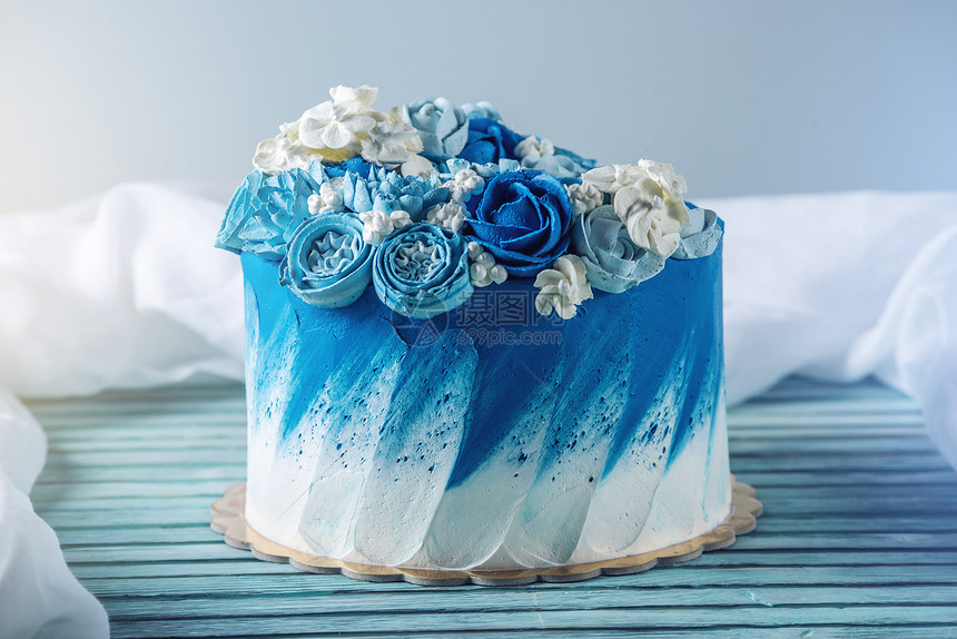 美丽的蓝色婚礼蛋糕装饰着白色的奶油花和一个标签的地方生日节图片