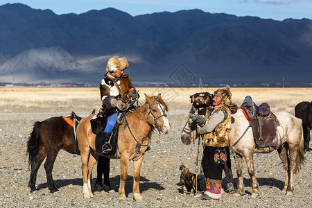 金鹰猎人教她年轻女儿与猎食鸟类一起捕猎西蒙古沙漠山的野兔图片
