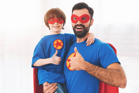我爸是超人父亲和儿子穿着超级英雄的红色和蓝色西装背景