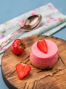 小圆草莓芝士蛋糕在木桌图片