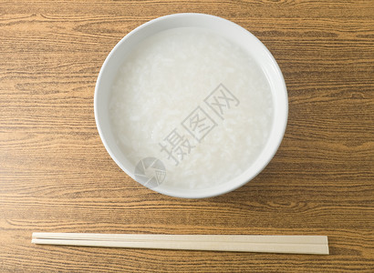 亚洲传统食品一碗亚洲大米粥或用竹棒背景图片