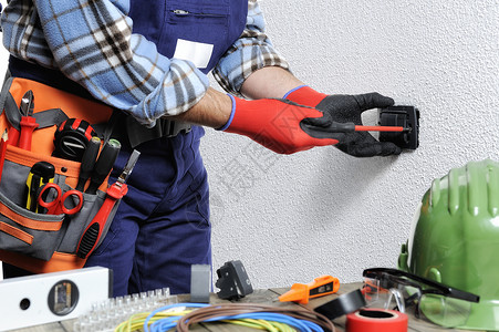 使用手套和隔热工具保护手的电工在住宅电气装置上工作单位背景图片