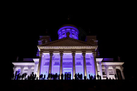 夜里人们在灯光明亮的赫尔辛基圣尼古图片