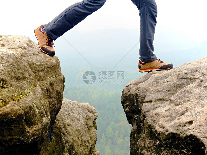 山顶上穿着黑色橙徒步靴的徒步行者腿细图在峰底穿鞋和图片