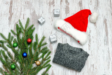 圣诞老人帽子装饰着花枝和灰色的毛衣图片