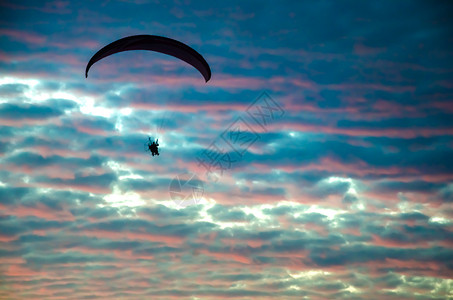 摩托滑翔伞在夕阳下高飞翔图片