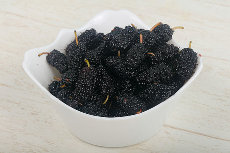 黑色的木莓堆在白碗中而图片