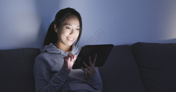 晚上在家看数字平板电脑的女人看图片