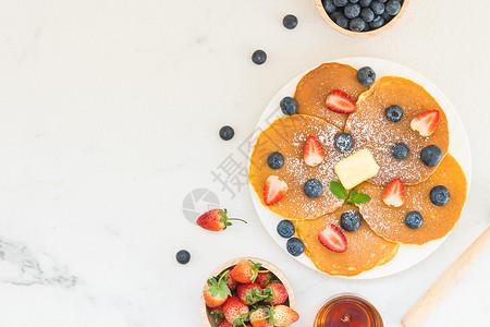 健康早餐煎饼蓝莓和草莓水果放在石桌图片