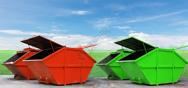 绿草蓝天背景下用于城市垃圾或工业垃圾的彩色工业垃圾箱图片
