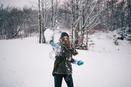 快乐的女人扔雪球背景图片