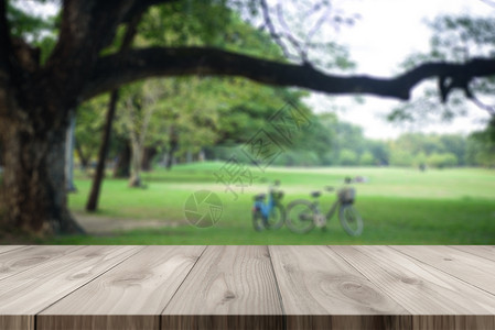 木桌面有绿色公园背景背景图片