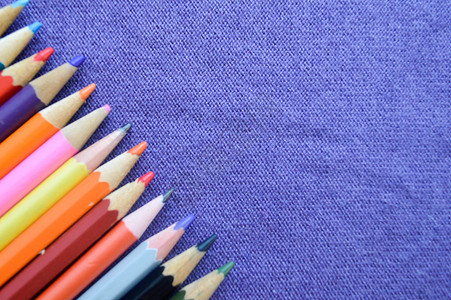多色亮彩色的铅笔用于绘制紫色布的背图片