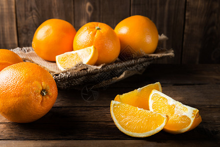深色木质背景上的新鲜成熟橙子图片