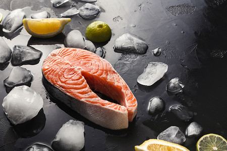 深底面带冰和柠檬片的新鲜鲑鱼图片