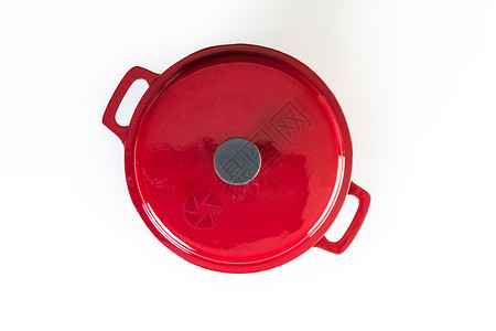 在白色背景的红色搪瓷铸铁盖了荷兰烤箱图片