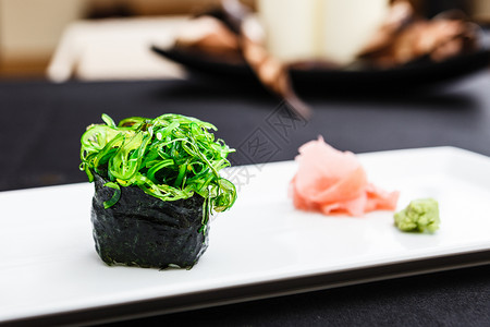 海藻寿司放在盘子上配上生姜和芥末图片
