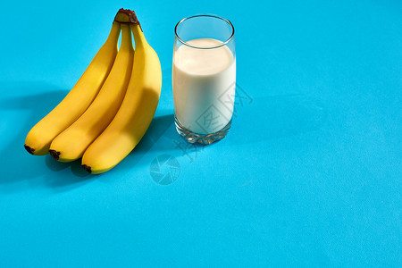 一杯牛奶黄香蕉熟透蓝色背景静态生图片