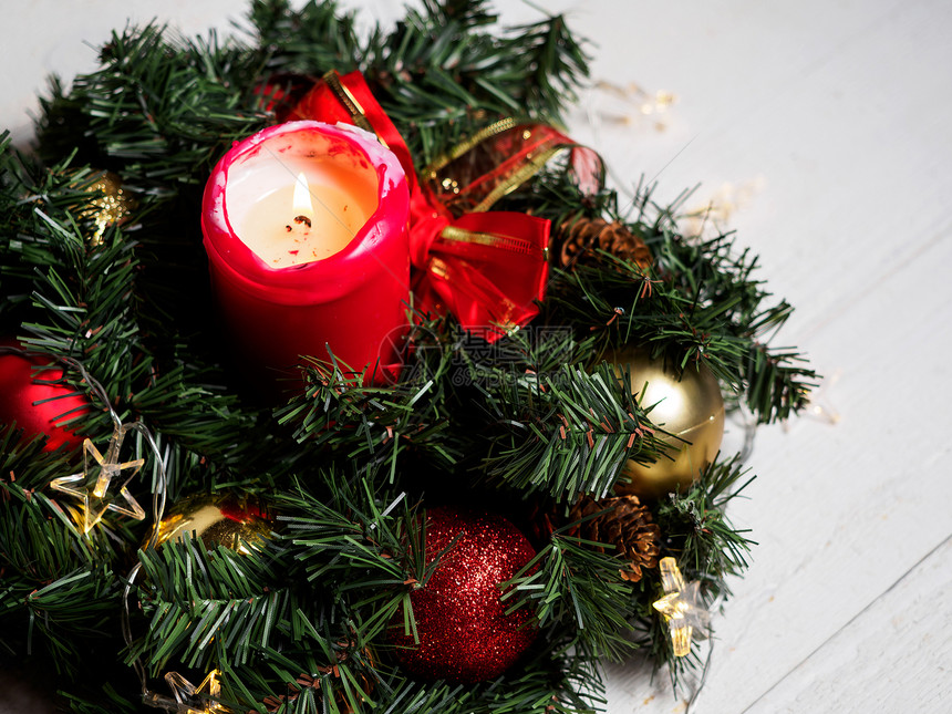 圣诞云杉树枝花环与木板上的蜡烛