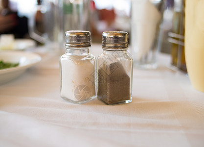 盐和胡椒放在桌子上的透明玻璃容器中图片