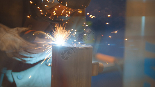 焊工在厂焊接金属零件特写图片