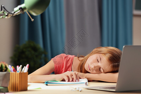 十几岁的女孩在餐桌上做作业时睡着了图片