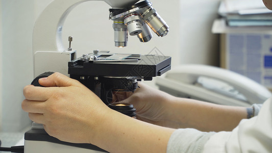 女医生在实验室里用显微镜工作女科学家通过实验室的显微镜看科学家在实验图片