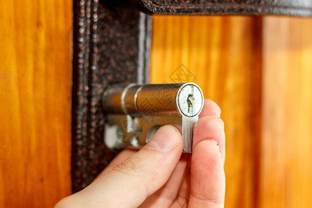 锁匠在木门上安装新的门锁图片