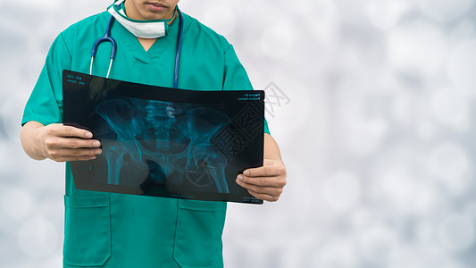 外科医生检查X光胶片诊断病人的腰骨图片