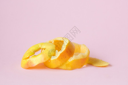 粉红背景上的黄苹果皮作为回收循环高清图片