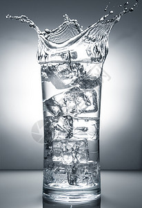 有冰和液体飞溅的玻璃杯图片