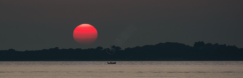 海上夕阳红日与渔船图片