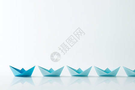 领导力概念由黑色蓝纸船连续在浅蓝色船背景图片
