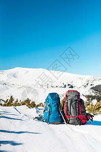 两个背包在雪山和蓝天的背景下雪地上的背包积极的生活方图片