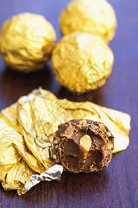 木桌上用金纸包裹的巧克力球图片