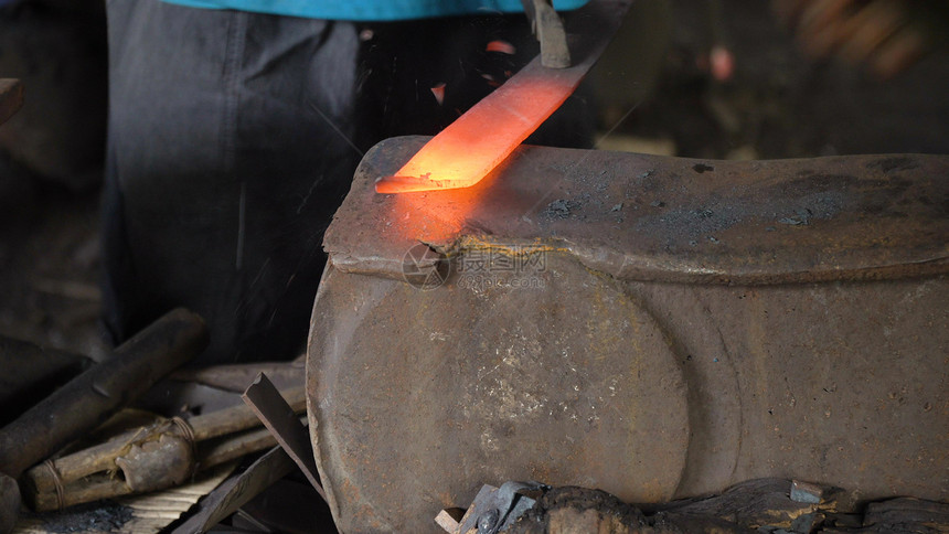 铁匠在锻造的铁砧上用锤子加工金属在铁砧上锤锻热铁匠制作砍刀由工作的铁匠图片