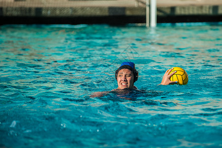 水球女运动员在寻找队友通过球时表现出强烈的表情图片