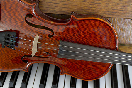 木制钢琴键上的古典小提琴钢琴上的古典小提琴音乐背景概念节日音乐图片