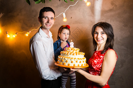 主题家庭假日儿童生日和吹灭大蛋糕上的蜡烛图片