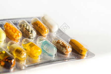 白色背景下透明药胶囊中各种彩色药丸的详细信息疾病医学概念图片