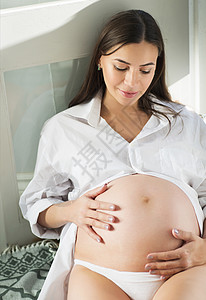 室内怀孕妇女坐在图片