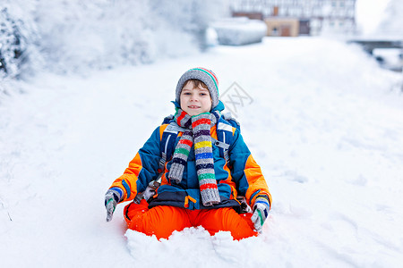 小学生在降雪期间步行去学校的小学男孩背景图片