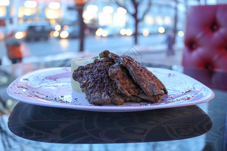 炸肉猪肉白盘上的牛肉在咖啡馆的桌子图片