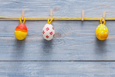 彩色花环与木背景上的彩绘鸡蛋质朴的桌面视图上色彩缤纷的假日装背景图片