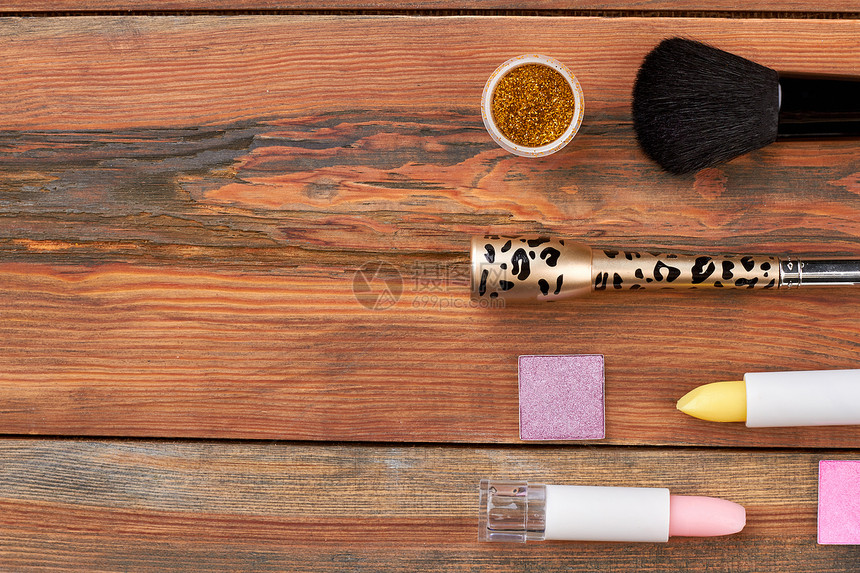 化妆品和木制背景上的工具棕色桌子上的专业刷子眼线笔口红文字空间化图片